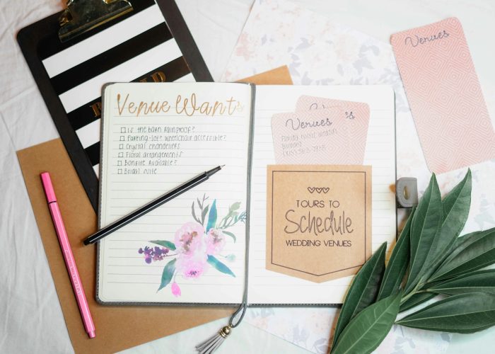 pexels-photo-811572-811572 Flat lay of wedding planning materials including a journal, leaves, and stationery.